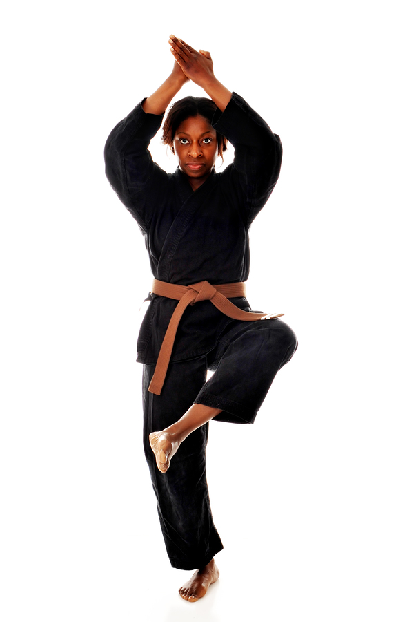 African American woman in a karate uniform and stance. Isolated on white.